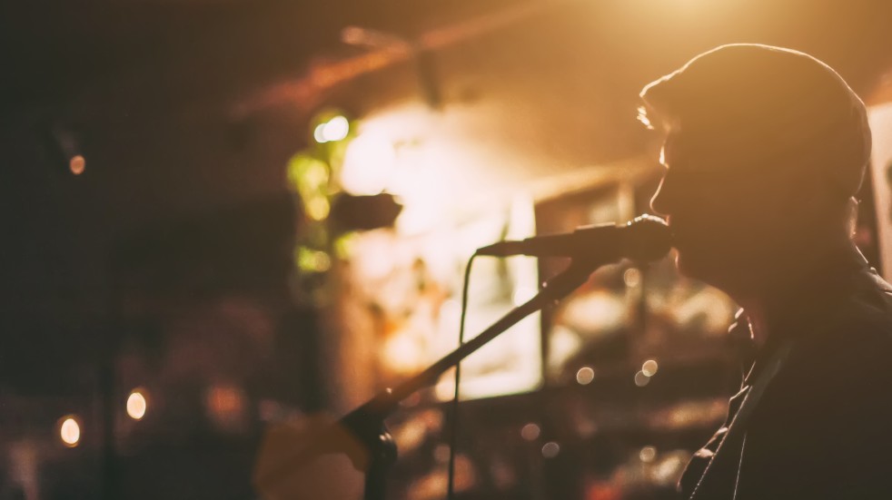 Free events July man singing into microphone